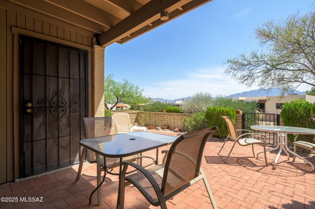 view of patio / terrace with a mountain view, fence, and outdoor dining space