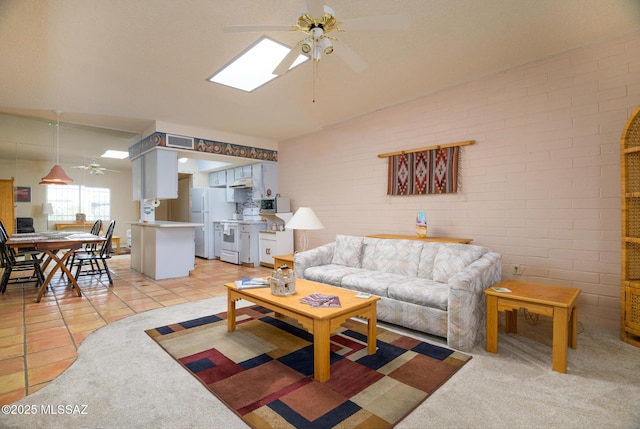 living room with brick wall, visible vents, light tile patterned floors, and a ceiling fan