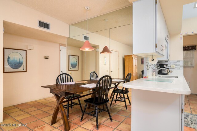 dining space with light tile patterned floors and visible vents