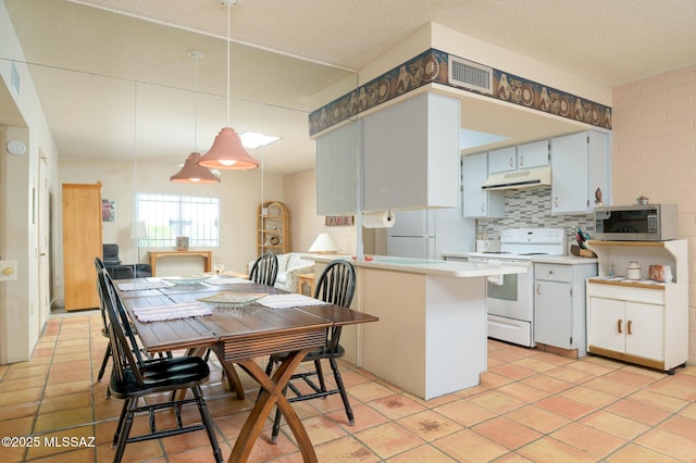 dining room with light tile patterned floors, a textured ceiling, and visible vents