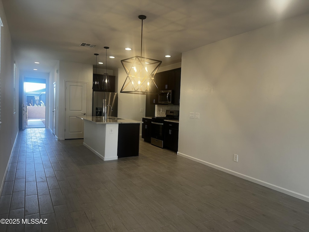 kitchen featuring visible vents, recessed lighting, appliances with stainless steel finishes, and a center island with sink