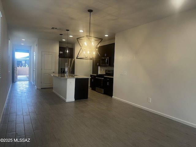 kitchen featuring visible vents, recessed lighting, appliances with stainless steel finishes, and a center island with sink