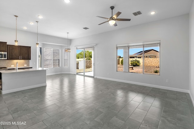 unfurnished living room featuring recessed lighting, a ceiling fan, visible vents, and a sink