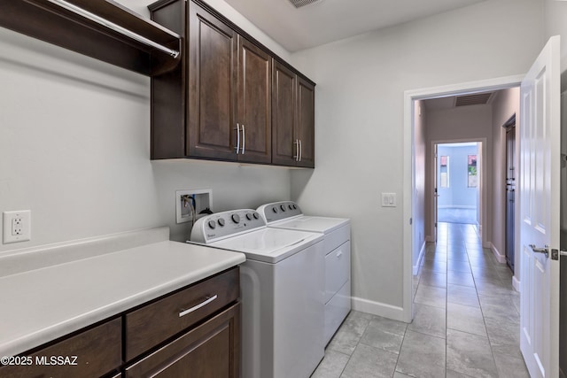 washroom with visible vents, baseboards, cabinet space, independent washer and dryer, and light tile patterned floors