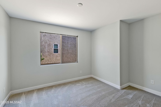 unfurnished room with baseboards and carpet flooring