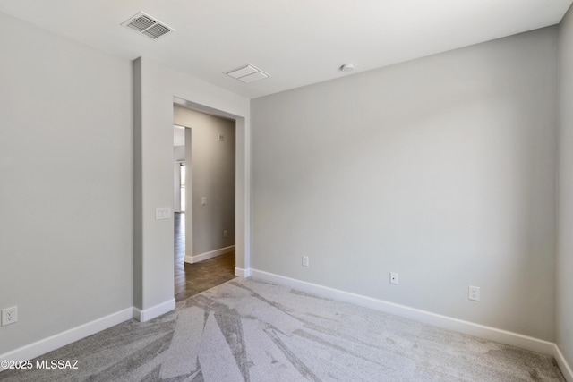 carpeted spare room with baseboards and visible vents