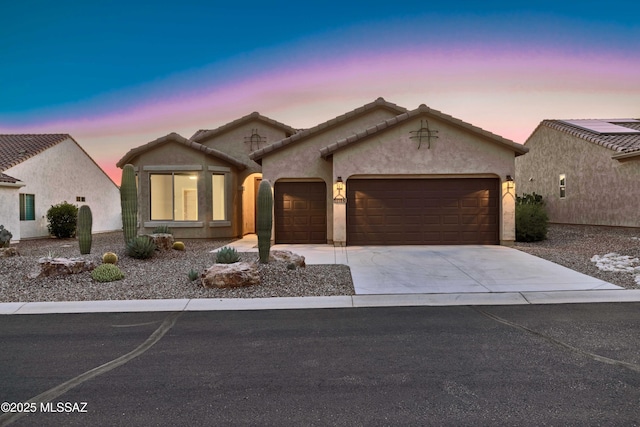 ranch-style home with an attached garage, concrete driveway, and stucco siding