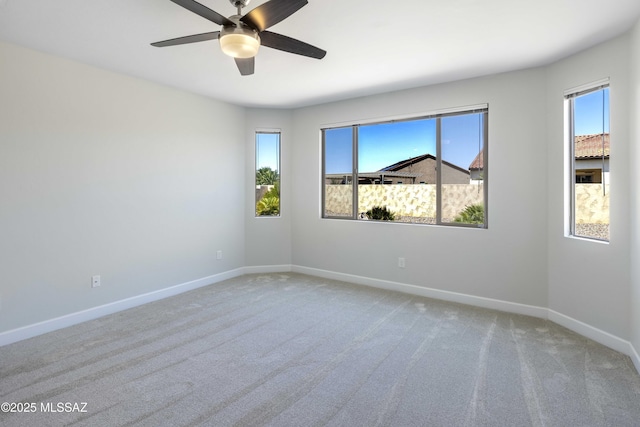 unfurnished room with baseboards, ceiling fan, carpet, and a wealth of natural light