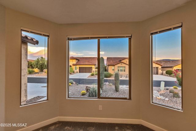 spare room featuring baseboards and carpet flooring