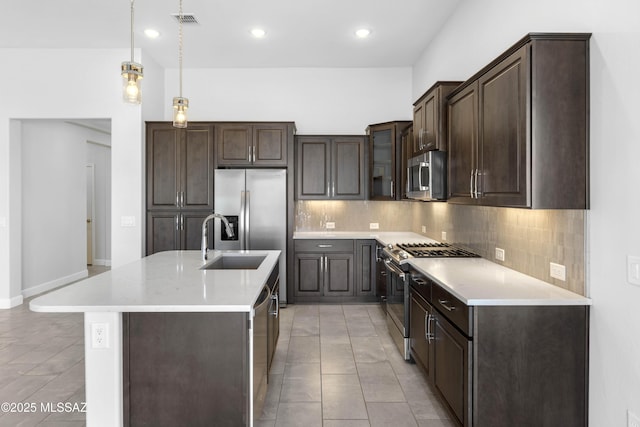 kitchen with light countertops, dark brown cabinetry, appliances with stainless steel finishes, and tasteful backsplash