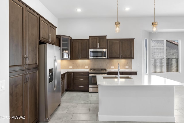 kitchen featuring decorative backsplash, light tile patterned flooring, light countertops, a sink, and appliances with stainless steel finishes