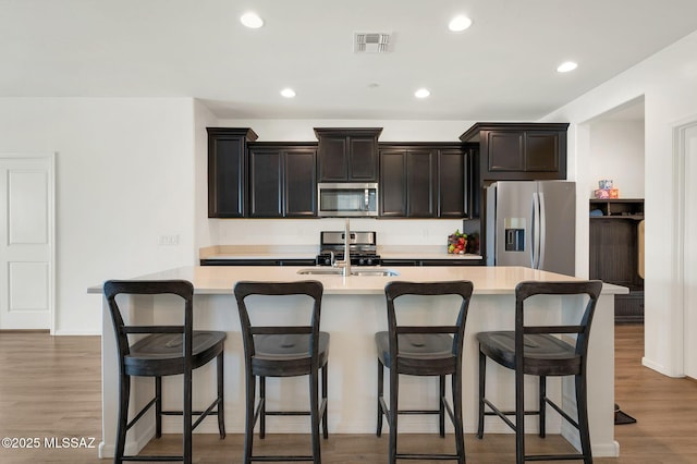 14239 E Axle Dr, Vail, AZ 85641 - kitchen featuring stainless steel appliances, a sink, light countertops, a kitchen island with sink, and light wood-style floors