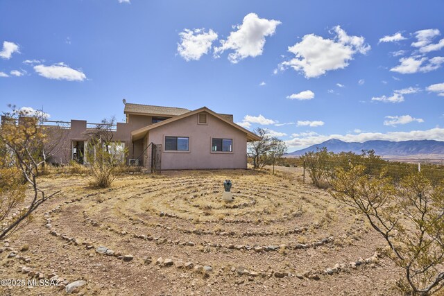 view of property exterior featuring stucco siding and a mountain view