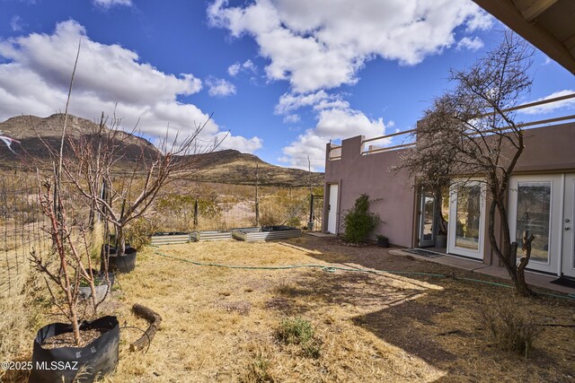 view of yard with a mountain view and french doors