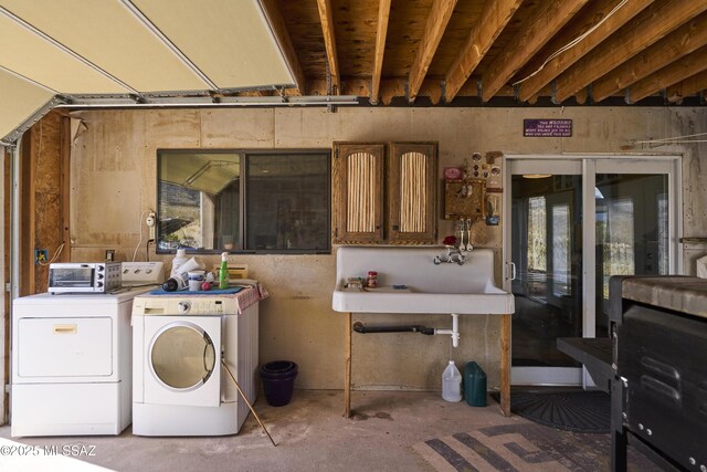 washroom with washer and clothes dryer, laundry area, and a sink
