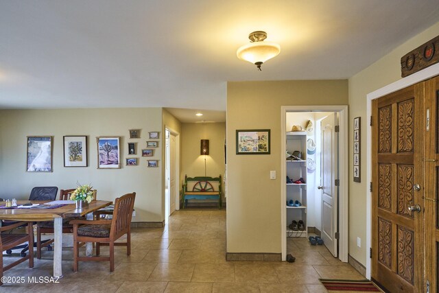 foyer featuring light tile patterned flooring and baseboards