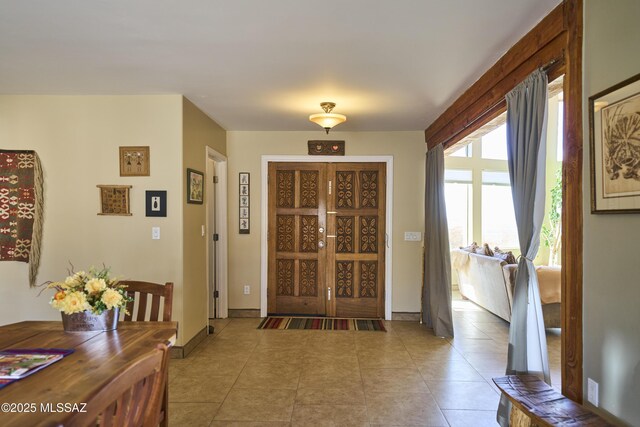 entrance foyer featuring light tile patterned floors and baseboards
