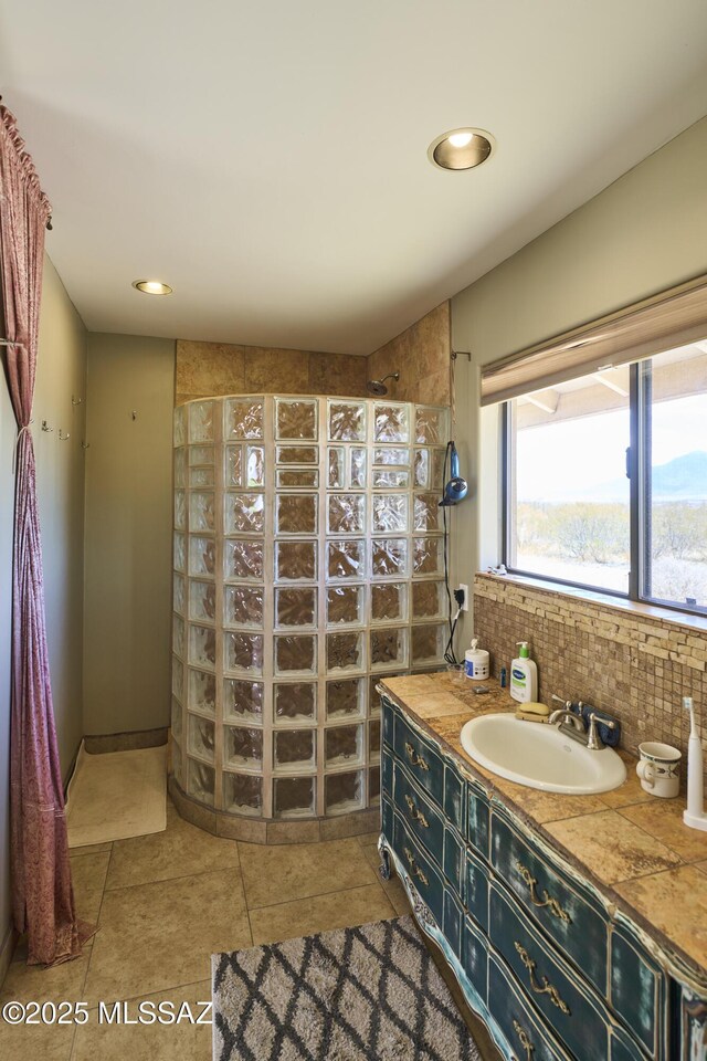 bathroom with decorative backsplash, recessed lighting, a walk in shower, and vanity