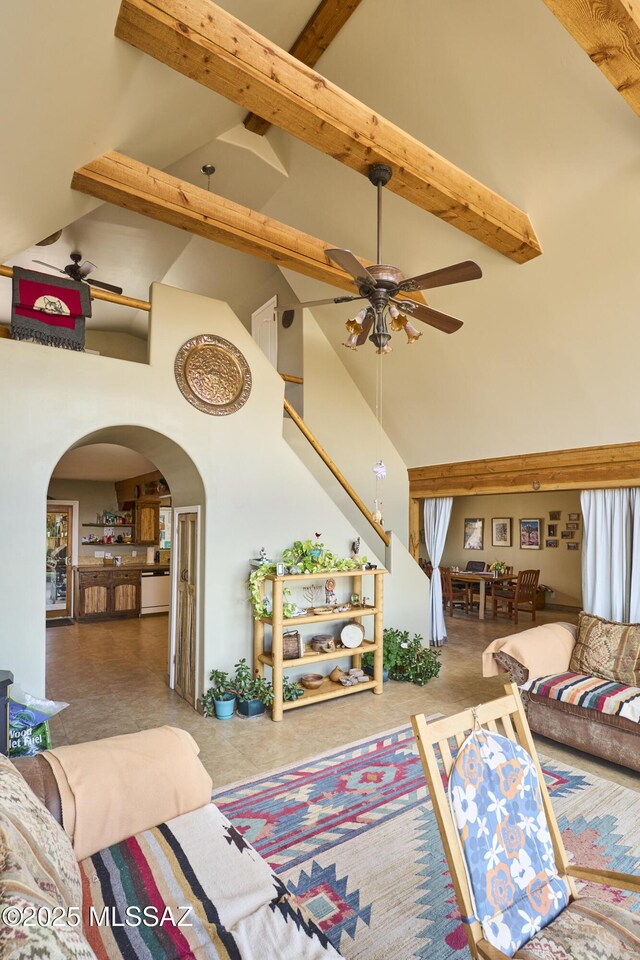 living room with beamed ceiling, high vaulted ceiling, arched walkways, and a ceiling fan