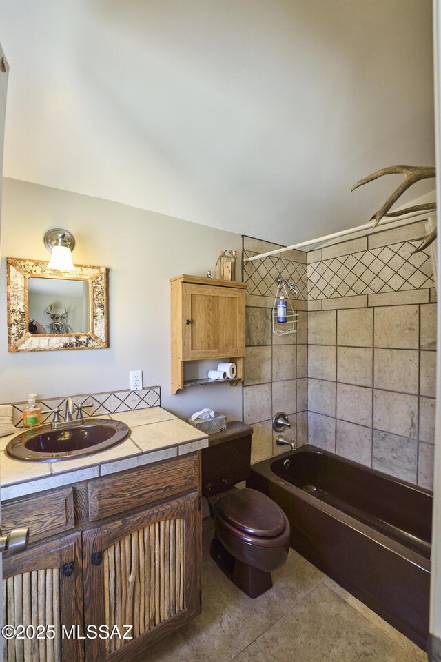 bathroom featuring tile patterned floors, toilet, vanity, and bathing tub / shower combination