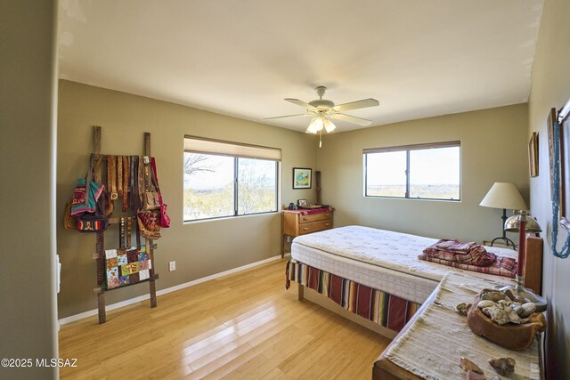 bedroom with baseboards, light wood-style floors, and a ceiling fan