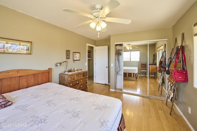 bedroom with a closet, baseboards, wood finished floors, and a ceiling fan