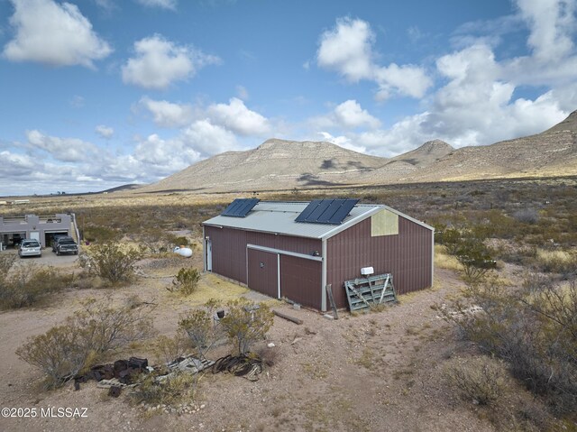exterior space featuring solar panels, driveway, and a mountain view