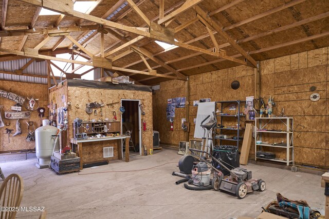 miscellaneous room with a workshop area, vaulted ceiling, and visible vents