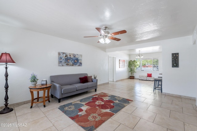 6517 E Cooper St, Tucson, AZ 85710 - living room featuring light tile patterned floors, ceiling fan, a chandelier, and baseboards