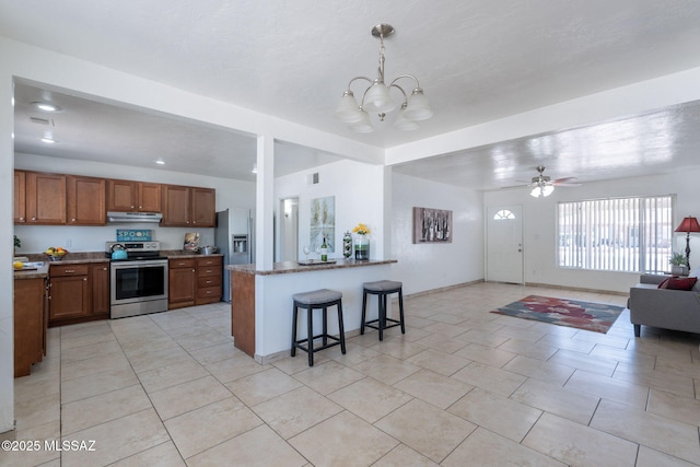 6517 E Cooper St, Tucson, AZ 85710 - kitchen featuring stainless steel range with electric stovetop, refrigerator with ice dispenser, open floor plan, under cabinet range hood, and a chandelier