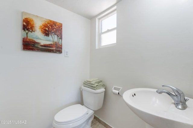 6517 E Cooper St, Tucson, AZ 85710 - half bath with a sink, toilet, and baseboards