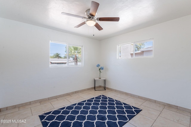 6517 E Cooper St, Tucson, AZ 85710 - unfurnished room with light tile patterned flooring, a ceiling fan, and baseboards