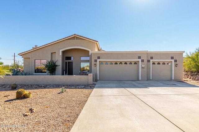 view of front of property with stucco siding, an attached garage, and concrete driveway