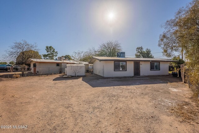rear view of house with central AC and fence