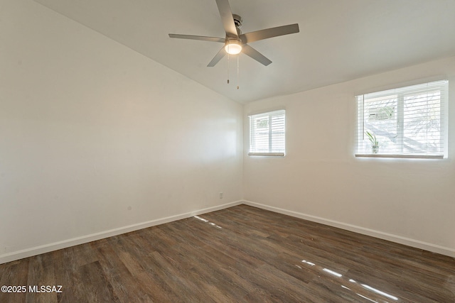 spare room with dark wood finished floors, baseboards, vaulted ceiling, and ceiling fan