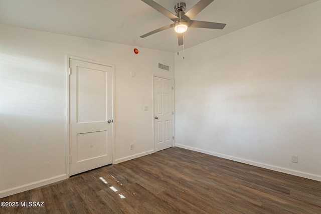 spare room with a ceiling fan, wood finished floors, lofted ceiling, baseboards, and visible vents