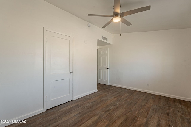 spare room featuring baseboards, visible vents, ceiling fan, and dark wood-type flooring