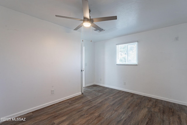 spare room featuring dark wood-type flooring, visible vents, baseboards, and a ceiling fan