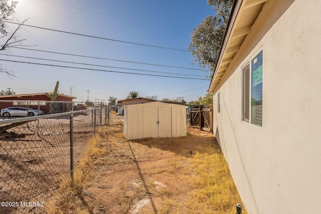 view of yard featuring an outbuilding, fence, and a storage shed