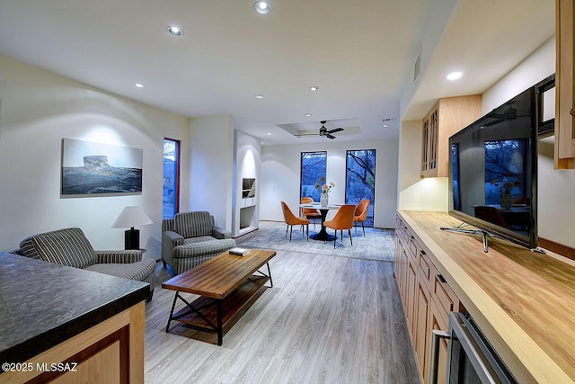 living area with recessed lighting, ceiling fan, visible vents, light wood-style flooring, and baseboards
