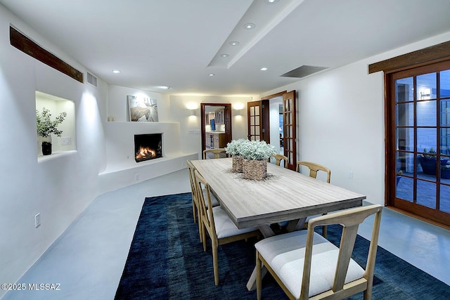 dining space featuring recessed lighting, visible vents, and a lit fireplace
