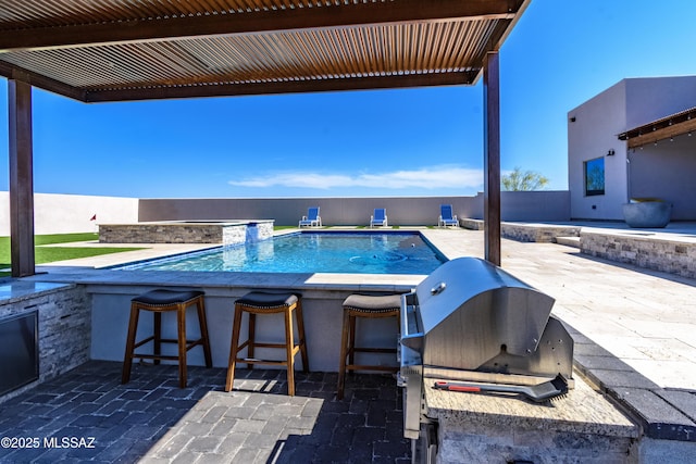 view of pool with exterior kitchen, a fenced in pool, grilling area, outdoor wet bar, and a patio area