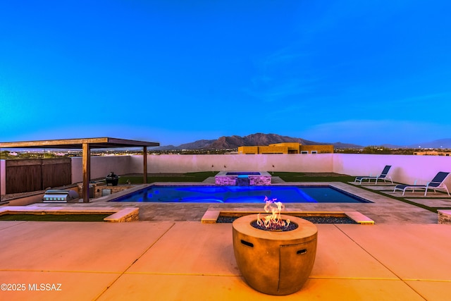 view of swimming pool featuring a fenced backyard, a patio, a fire pit, a mountain view, and a fenced in pool