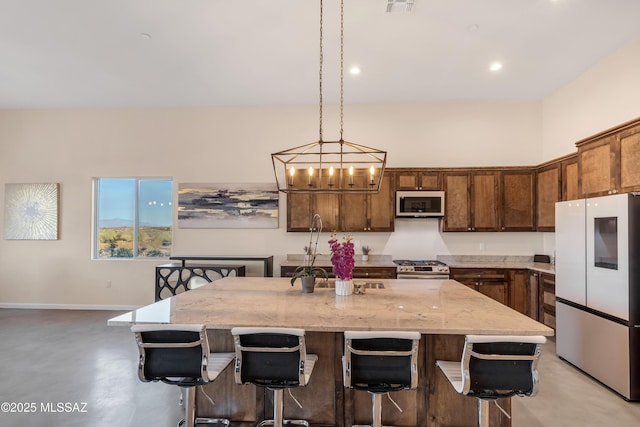 kitchen featuring white microwave, stainless steel gas stove, light stone countertops, smart refrigerator, and a breakfast bar area