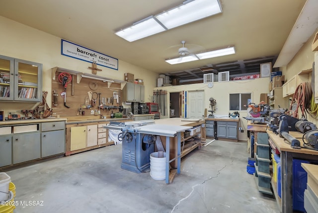 garage with a workshop area, ceiling fan, and visible vents