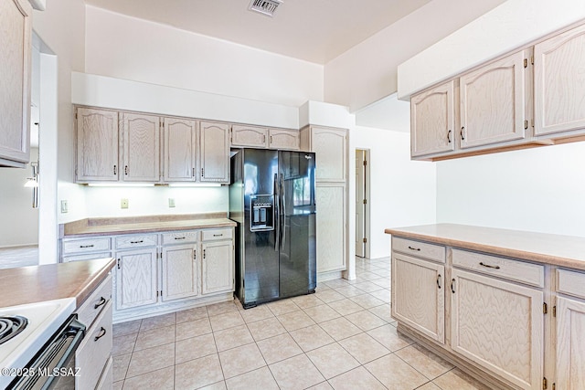 4661 S Desert Grove Ct, Green Valley, AZ 85622 - kitchen with black fridge, light tile patterned floors, visible vents, light countertops, and electric stove