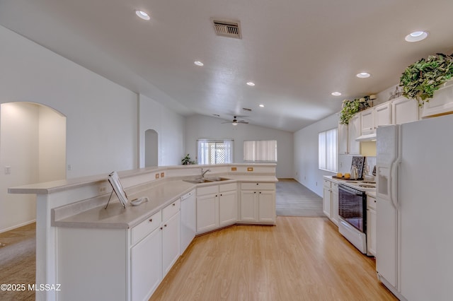 kitchen featuring vaulted ceiling, white appliances, a sink, ceiling fan, and visible vents