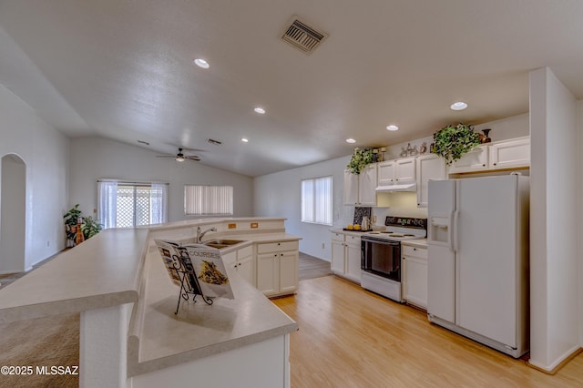 kitchen with vaulted ceiling, a sink, light wood-type flooring, white appliances, and visible vents