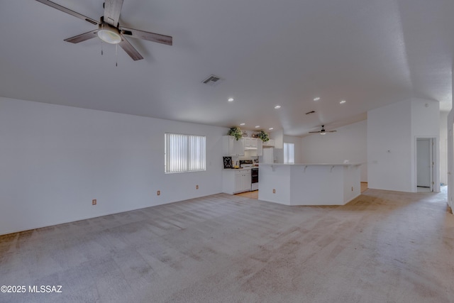 unfurnished living room featuring light colored carpet, visible vents, lofted ceiling, and a ceiling fan