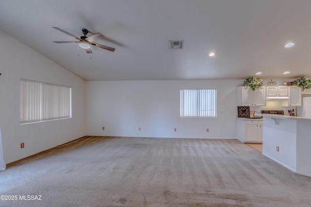 unfurnished living room featuring a ceiling fan, light carpet, lofted ceiling, visible vents, and recessed lighting